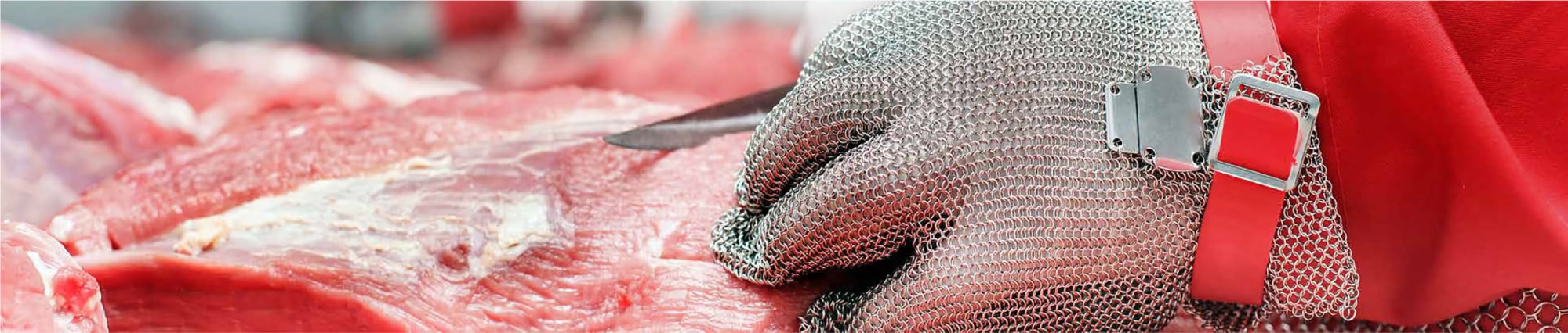 butcher cutting meat wearing a protective glove